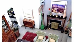 Un salón con un sofá, dos sillones, una mesa de centro y un televisor de pantalla plana.
