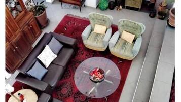 Un salon comprenant un canapé, deux fauteuils, une table basse et un téléviseur à écran plat.