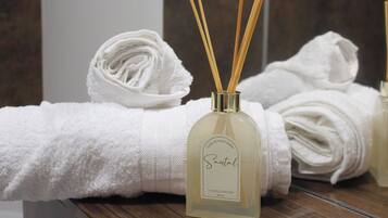 Ein Badezimmer mit einem weißen Handtuch, einem Santal-duftenden Diffusor und Schilff diffusoren.