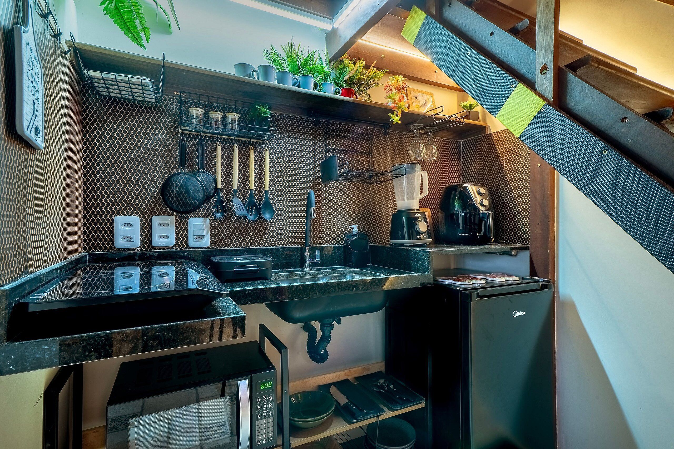 A compact kitchen with a sink, stove, and various utensils.