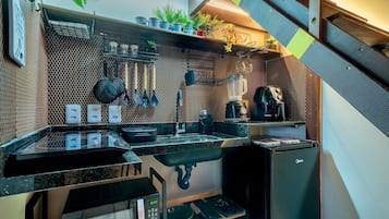 A compact kitchen with a sink, stove, and various utensils.