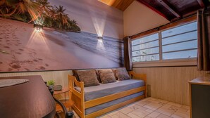 Een kamer met een houten bank, een eettafel en een groot raam.