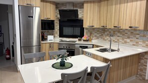 A compact kitchen with a refrigerator, microwave, oven, and sink. - Villa Soleada - Private Pool - Beach 10 minutes away (San Pedro del Pinatar)