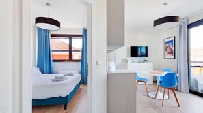 Une chambre d’hôtel moderne équipée d’un lit, d’un bureau et d’une télévision.