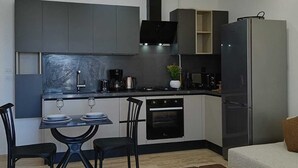 A modern kitchen with a dining area, a built-in oven, a refrigerator, and a coffee maker. - Dream Apartment in Jardins de Carthage (Résidence luxoria)