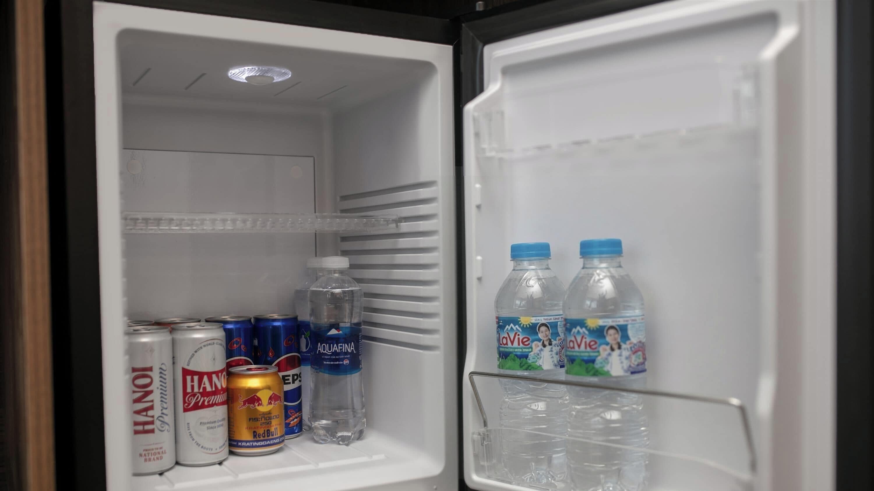 An open refrigerator with beverages and cans.