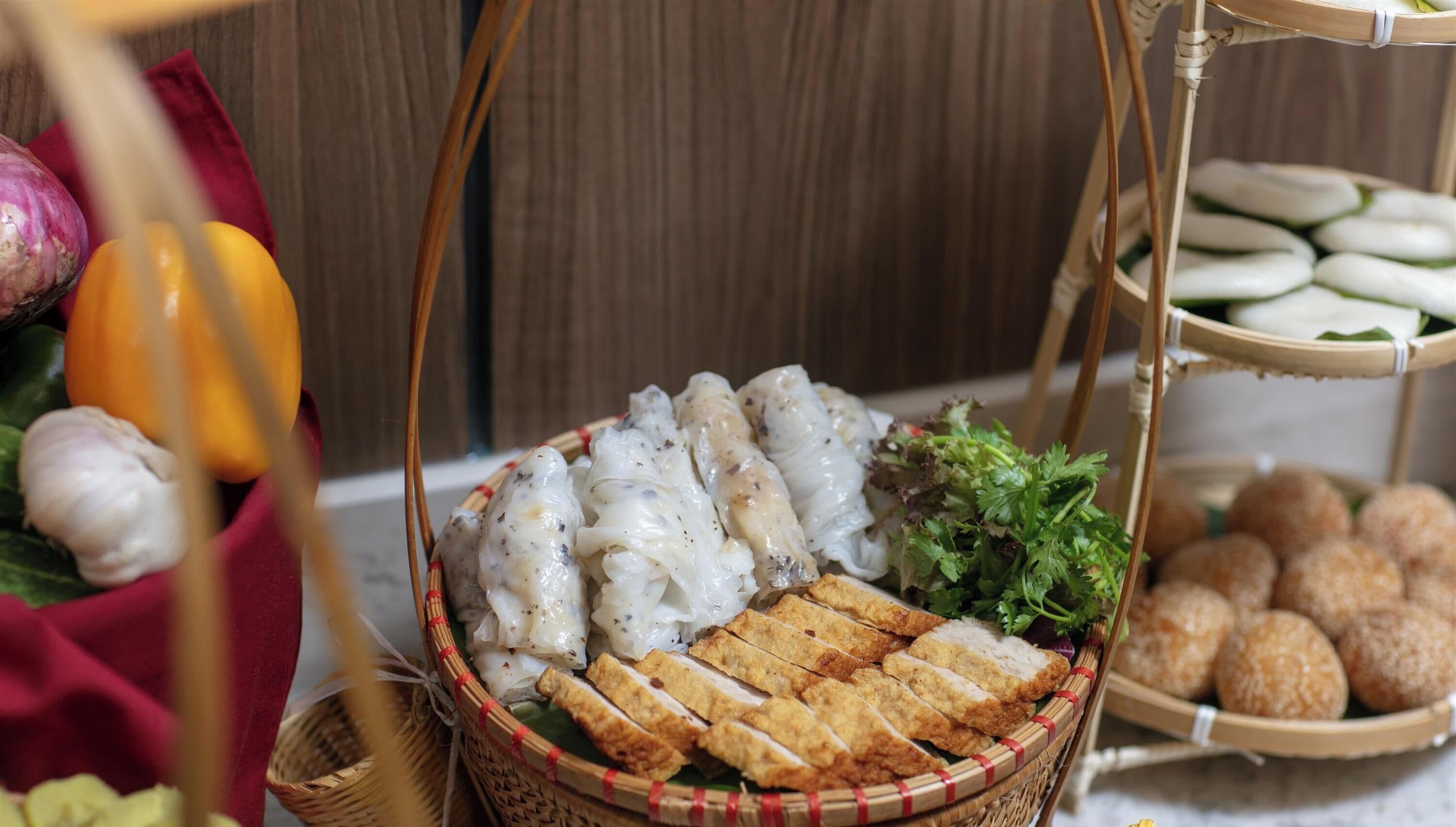 Variedad de alimentos como rollitos primavera, pollo frito y otros platos, dispuestos sobre una mesa.