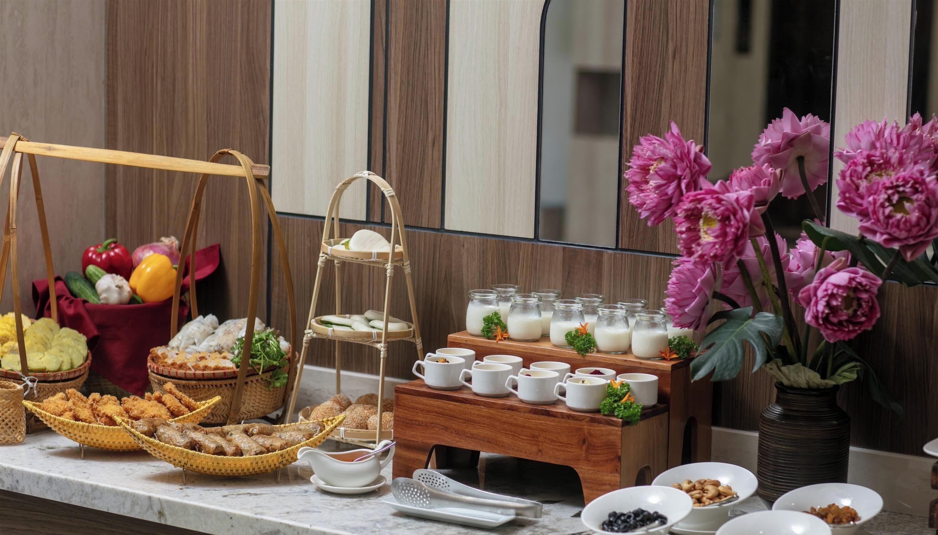 A buffet setup with various food items, including fruits, vegetables, and dairy products, arranged on a marble countertop.