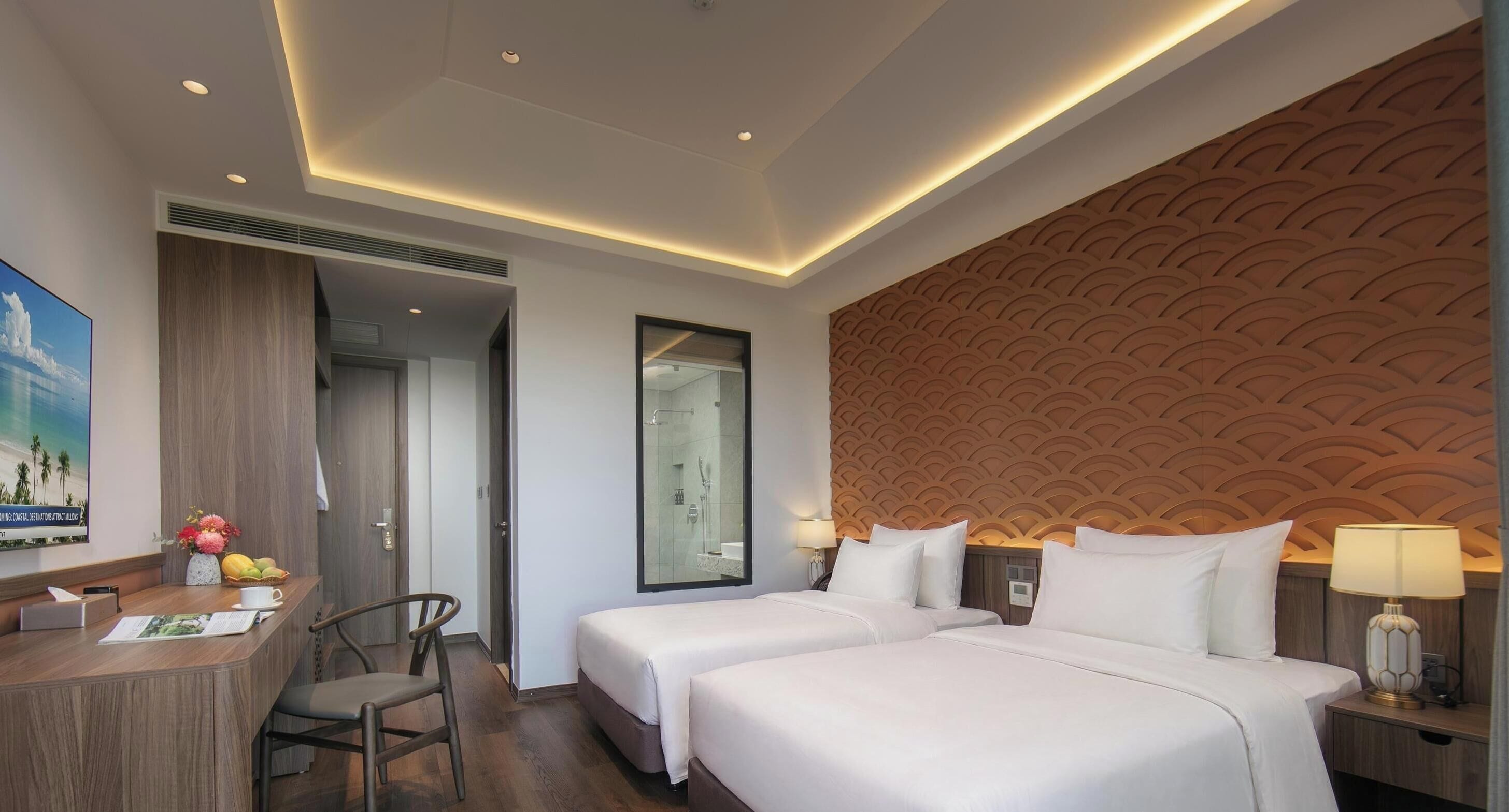 Une chambre d’hôtel avec deux lits, un bureau, une chaise, une douche et un mur décoratif.