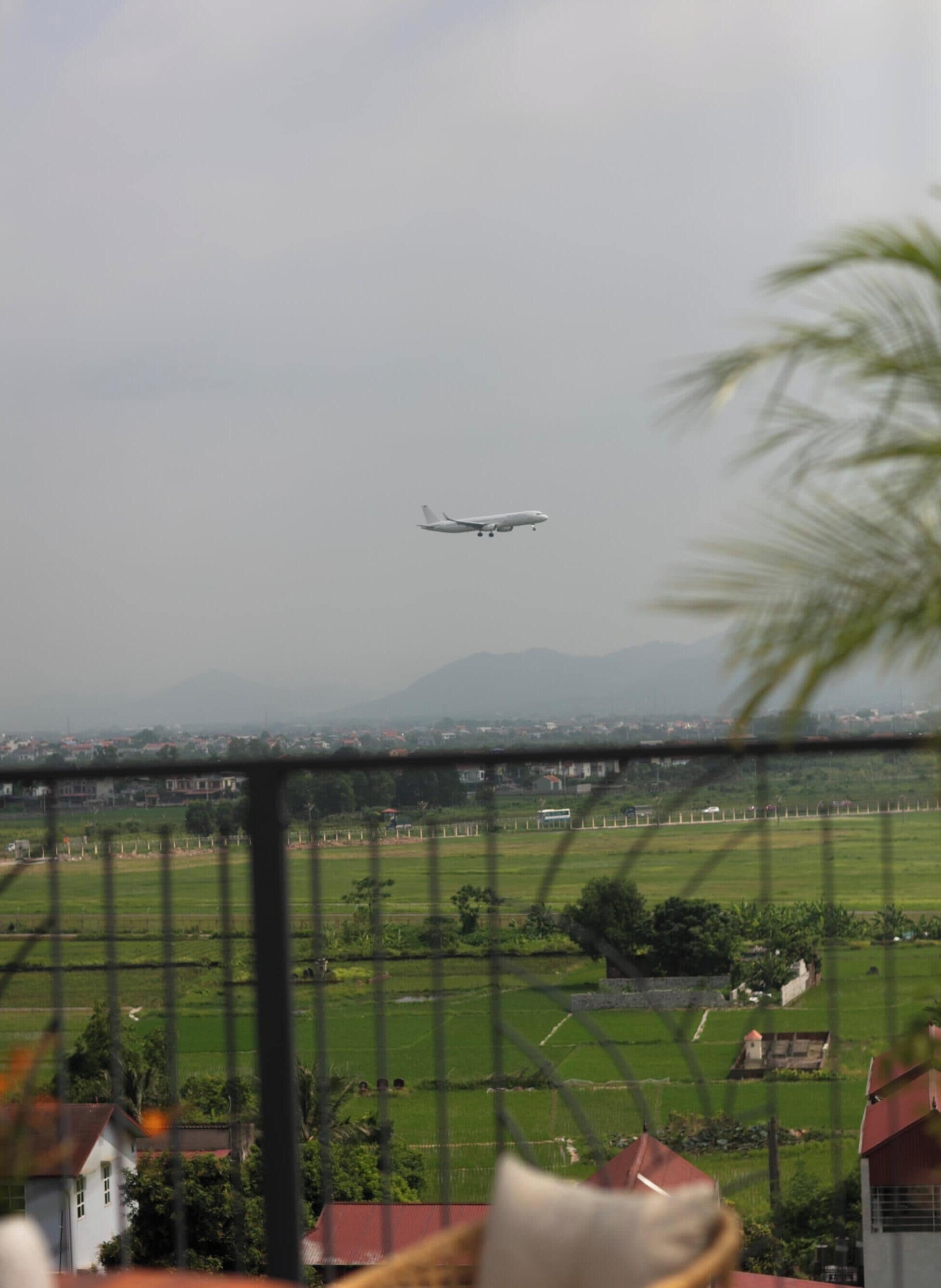 Un avión volando sobre un paisaje rural con campos y casas.