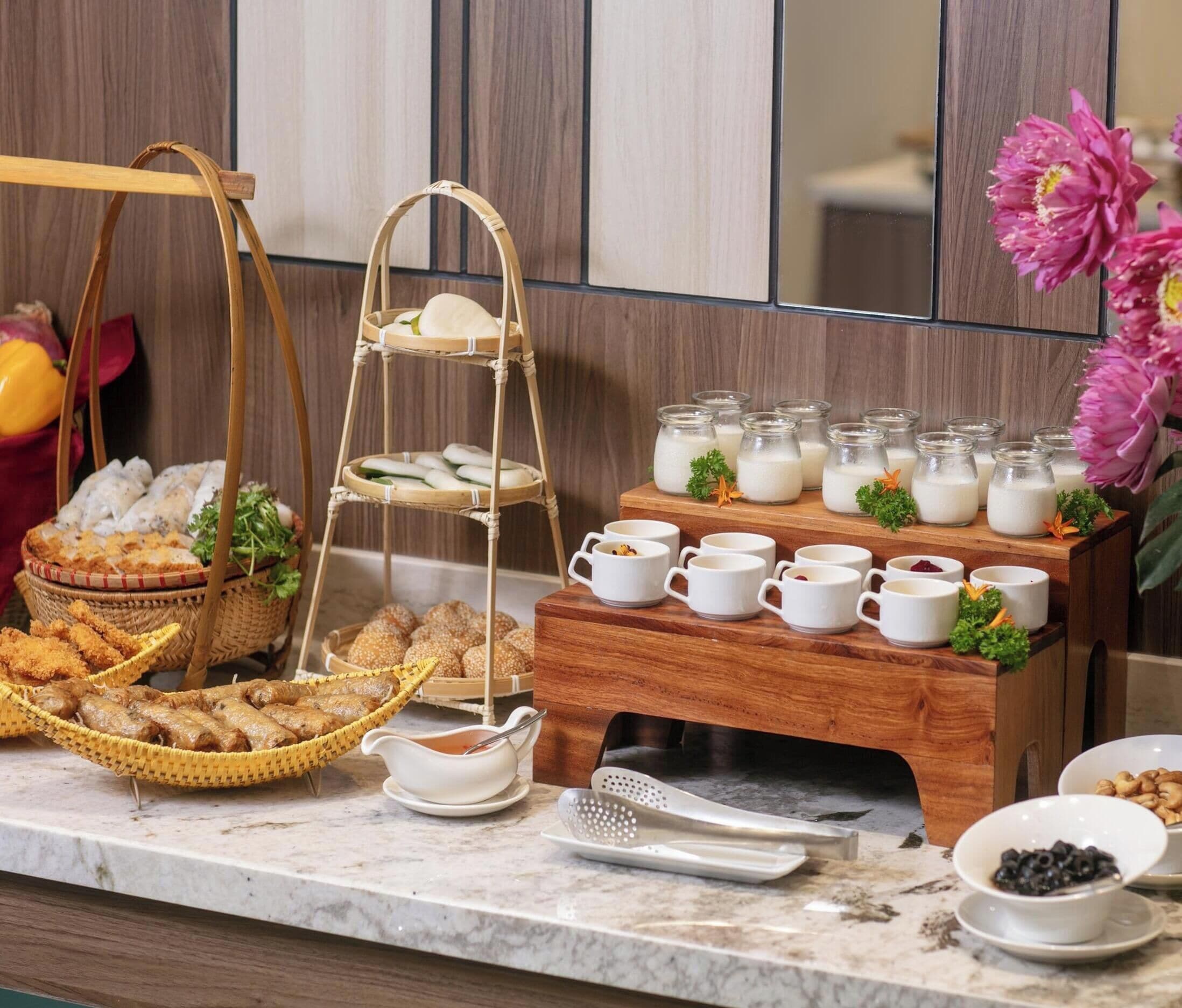 A buffet setup with various food items, a beverage station, and a decorative flower arrangement.