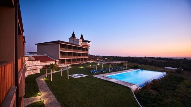 A hotel with a swimming pool, a covered outdoor area, and a view of the surrounding landscape. - Bakucha Vineyard Hotel ve Spa (Luleburgaz)
