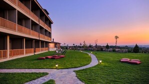 A hotel with a long corridor, outdoor seating, and a pathway leading to a scenic view. - Bakucha Vineyard Hotel ve Spa (Luleburgaz)