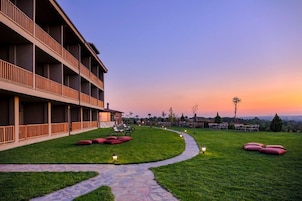 Um hotel com um corredor longo, área de estar ao ar livre e um caminho que leva a uma vista panorâmica.