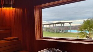 A wooden sauna room with a window view of a bridge and a body of water. - Bakucha Vineyard Hotel ve Spa (Luleburgaz)
