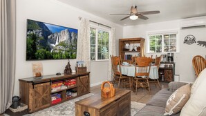 A living room with a television, dining table, chairs, and a sofa. - Yosemite Retreat Near Bass Lake with Firepit, BBQ & Sauna (Oakhurst)