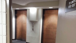 A hallway with a sign indicating unit numbers 1213-1227. - Unique Bishop Loft (Honolulu)