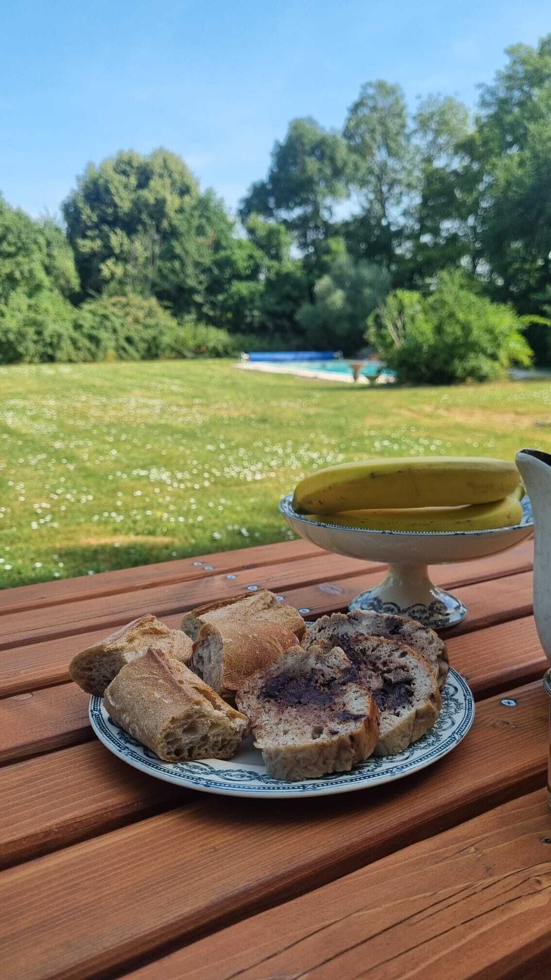 Une table en bois avec une assiette de pain et un bol de soupe.