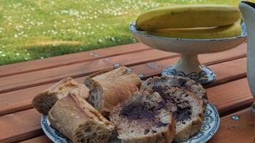 Une table en bois avec une assiette de pain et un bol de soupe.
