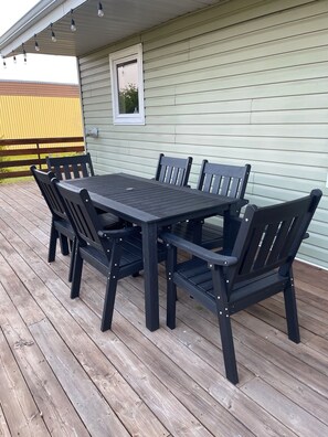 A wooden deck with a table and chairs.