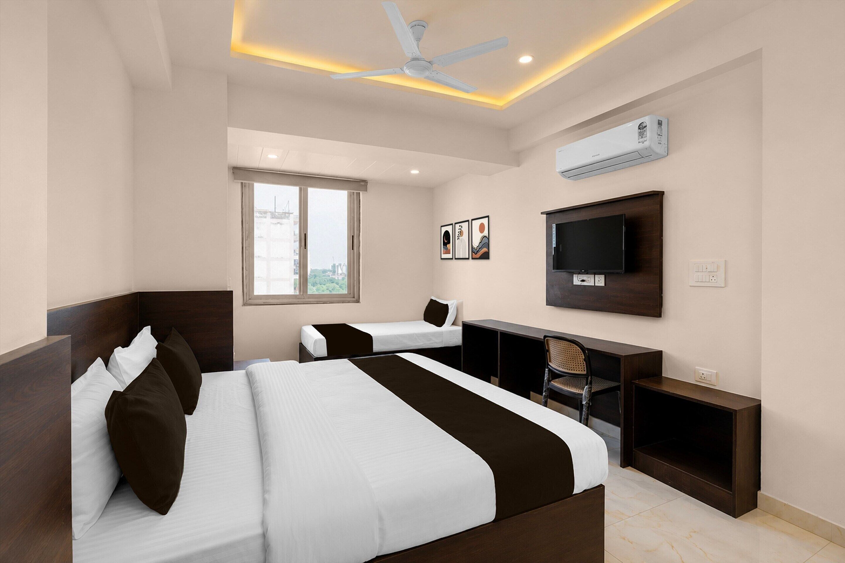 Une chambre d’hôtel équipée d’un lit, d’un bureau, d’une chaise, d’une télévision et d’un appareil de climatisation.