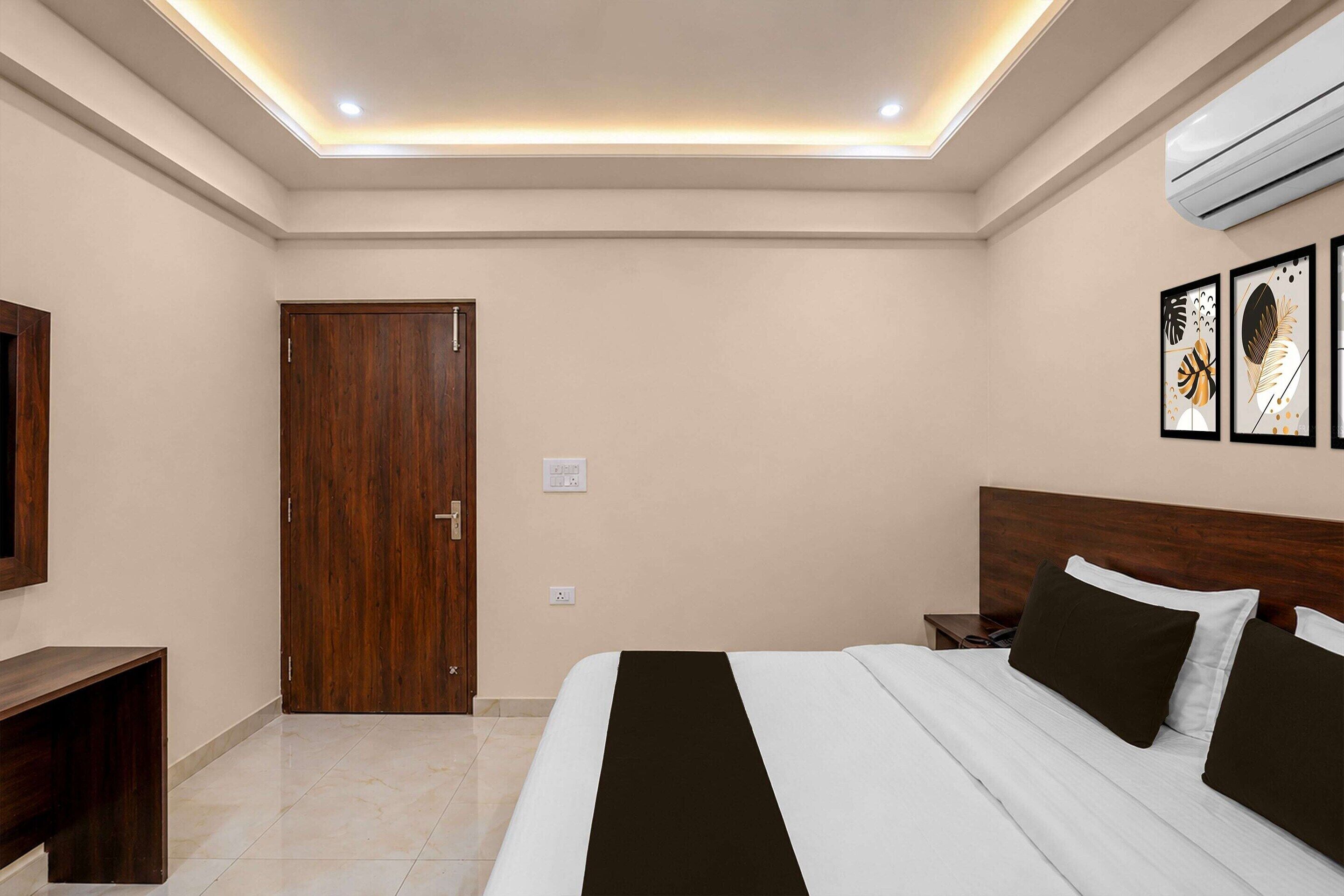 Une chambre d’hôtel comprenant un lit, des tables de chevet, une armoire et un luminaire au plafond.