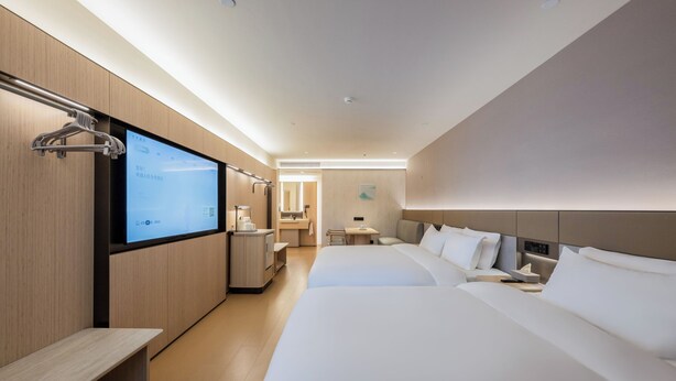 A modern hotel room with a large bed, a desk, a TV, and a bathroom in the background. - JI Hotel Fuzhou Railway Station  (Fuzhou)