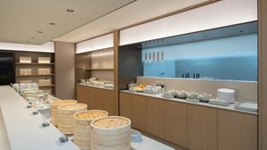 A modern breakfast buffet with a long counter, wooden baskets, and neatly arranged food items. - JI Hotel Fuzhou Railway Station  (Fuzhou)