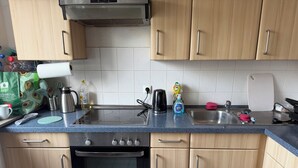 A kitchen with a stove, oven, sink, and various kitchen items.