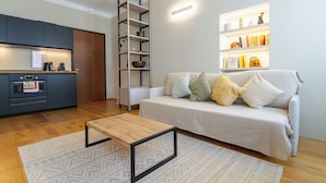 Una sala de estar moderna con sofá, mesa de centro y estanterías empotradas con libros y objetos decorativos.