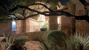 Un jardín árido con cactus y un muro de piedra.