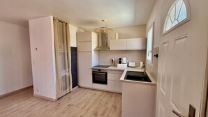 A compact kitchen with a built-in oven, a sink, and a window. - La'PaillotteduBassin Vacation Rental (Le Teich)