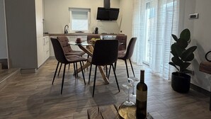 Une cuisine moderne avec un coin repas, un téléviseur à écran plat et une plante en pot.