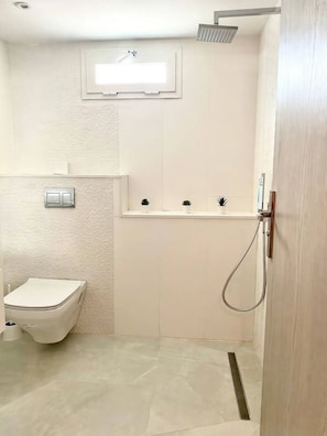 Un baño con inodoro, ducha y lavamanos.