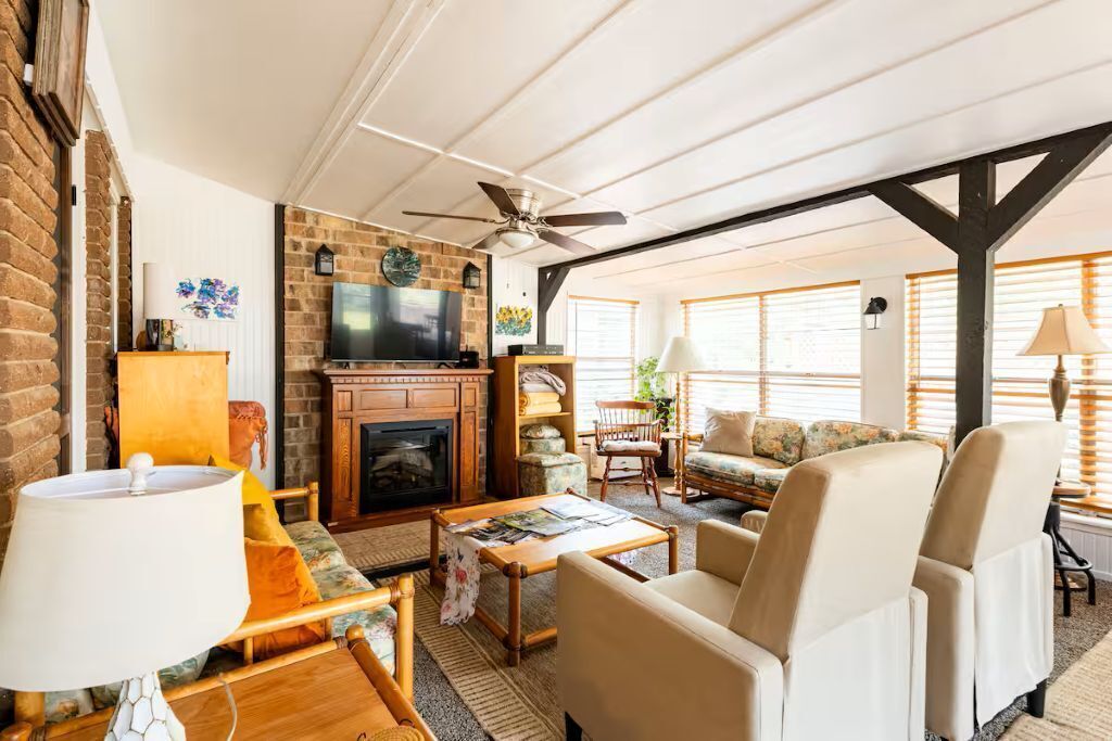 A cozy living room with a fireplace, comfortable seating, and a television.