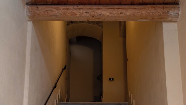 Eine Treppe mit Marmorstufen, Holzhandläufen und beigen Wänden.