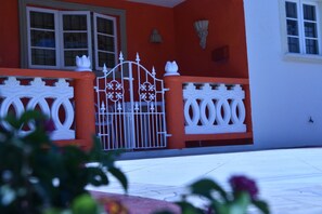 A building with a white gate, orange walls, and a white balcony railing. - Christoph Escape Barbados (Bridgetown)