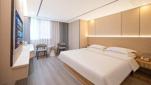 A modern hotel room with a bed, bedside table, lamp, and a desk with a chair. - Pebble Motel Fuzhou Fuxin Middle Road (Fuzhou)