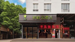 A hotel with a modern facade, a visible entrance, and signage indicating a restaurant inside. - Pebble Motel Fuzhou Fuxin Middle Road (Fuzhou)