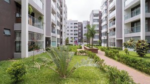 A modern apartment complex with multiple floors, balconies, and a central garden area. - Modern 1BR Near JKIA & SGR | Pool, Gym & Free Parking (Nairobi)