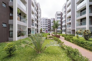 A modern apartment complex with multiple floors, balconies, and a central garden area. - Modern 1BR Near JKIA & SGR | Pool, Gym & Free Parking (Nairobi)