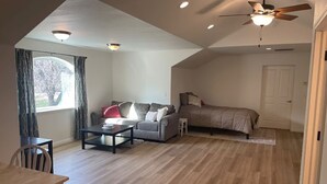 A spacious loft bedroom with a large bed, a ceiling fan, and a view of a tree through a window. - Peaceful Gold Country Studio Near Yosemite & Black Oak Casino (Tuolumne)