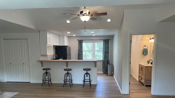 A spacious kitchen with a central island, bar stools, and a ceiling fan. - Peaceful Gold Country Studio Near Yosemite & Black Oak Casino (Tuolumne)