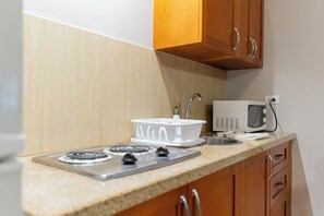 A kitchen with a stove, microwave, and sink.
