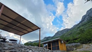 Eine Steinsäule, eine Holzkonstruktion und eine Bergkulisse.