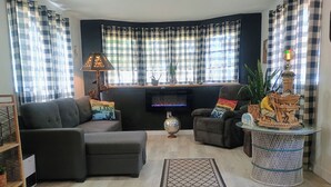 Ein Wohnzimmer mit Sofa, Sessel und einem kleinen Tisch mit Globus und Dekoration.