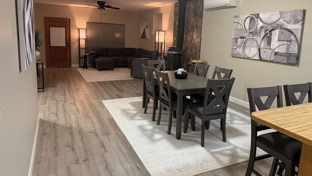 A living room with a sofa, a dining table with chairs, a fireplace, and a ceiling fan. - 1-bedroom apartment with AC near Lake Oroville (Oroville)