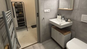 A modern bathroom with a sink, toilet, and a mirror.