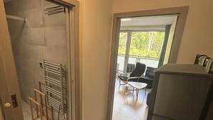A modern interior with a glass door leading to a balcony, a seating area with a table and chairs, and a built-in bench.
