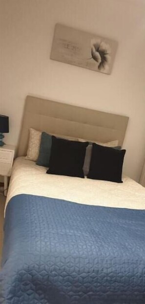 A bedroom with a bed, a nightstand, and a wall-mounted artwork. - Nazaré - 10 minutes from the ocean (montholon)